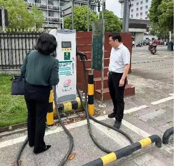 龚宇在城区检查电动车充电桩安全工作