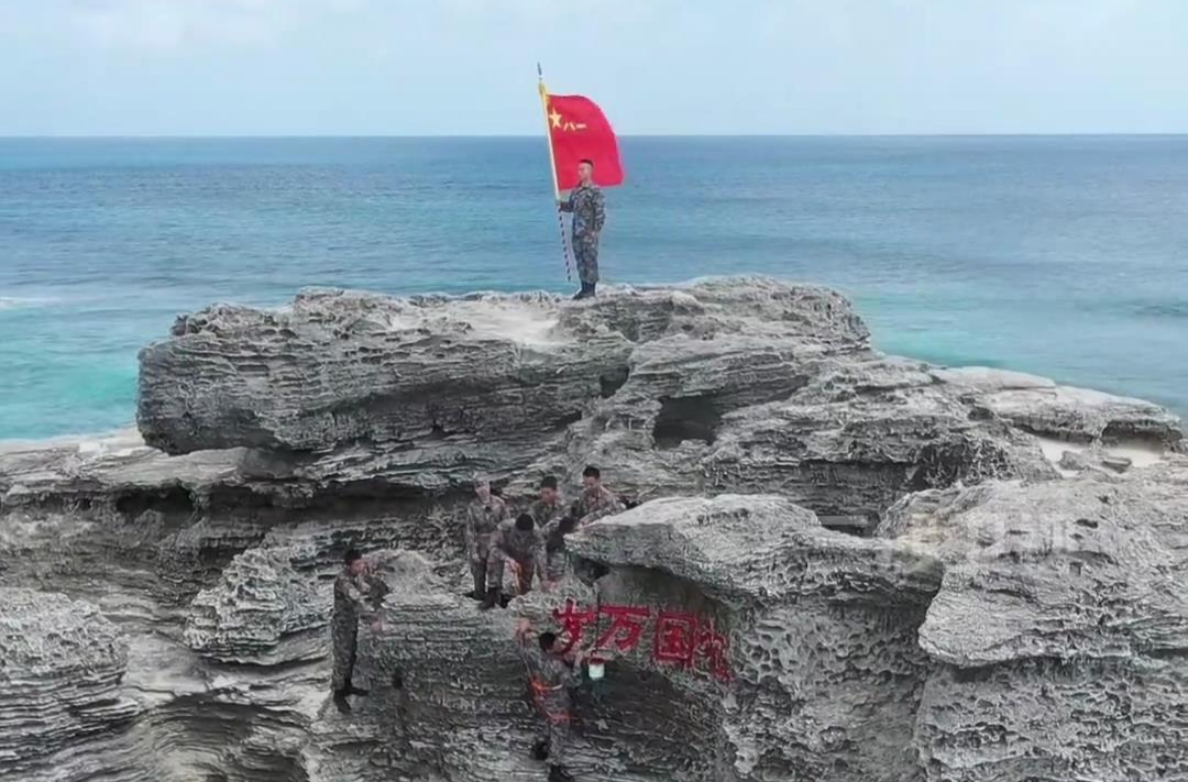八一建军节，三沙驻岛战士们攀礁石为“祖国万岁”描红，感悟西沙精神