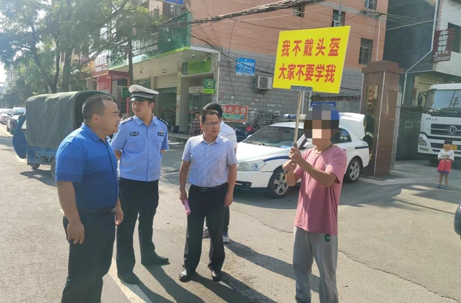 新店坪镇：道路交通安全执法出新招 不戴头盔接受“举牌教育”